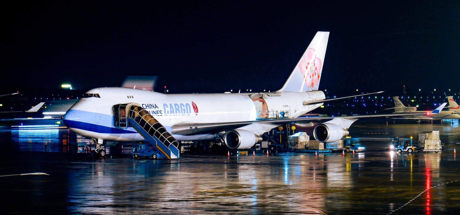 Cargo aircraft being prepared on an airport apron at night