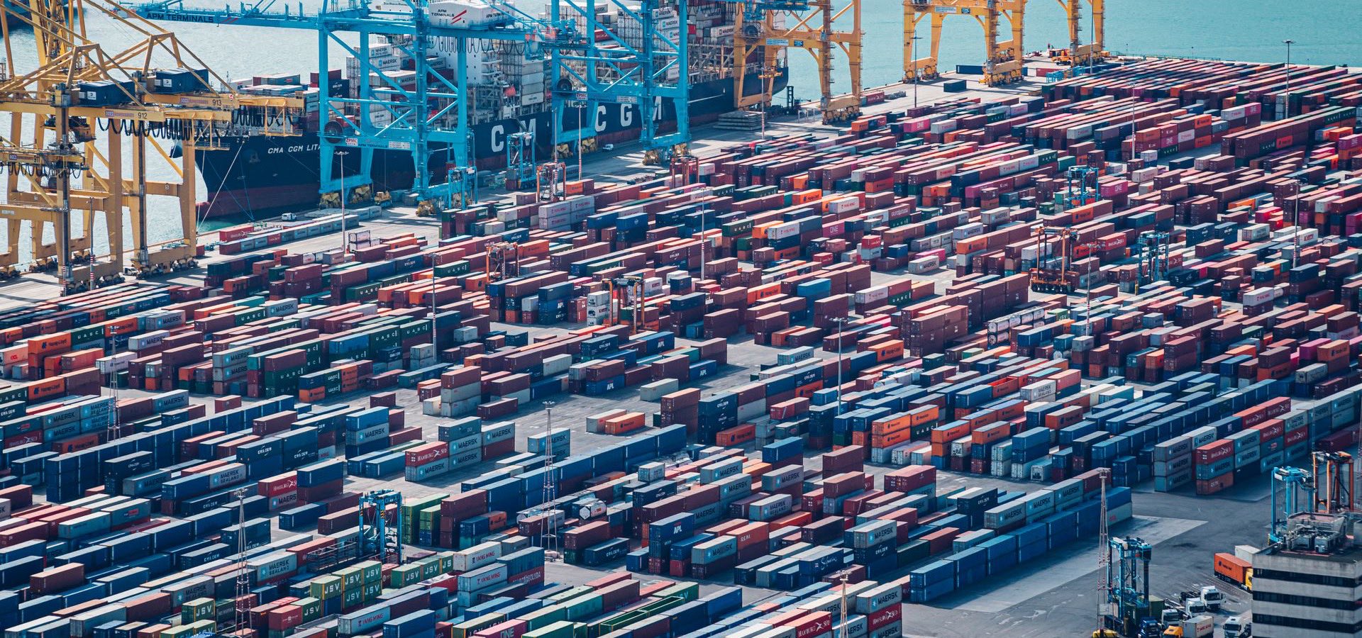 Aerial view of a port terminal with thousands of containers stacked along the quays