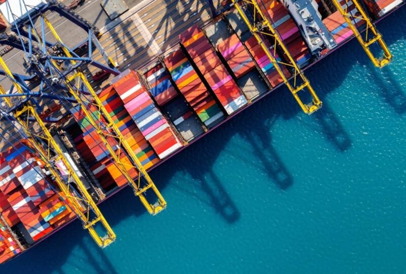 Aerial view of container vessels being worked by quay cranes