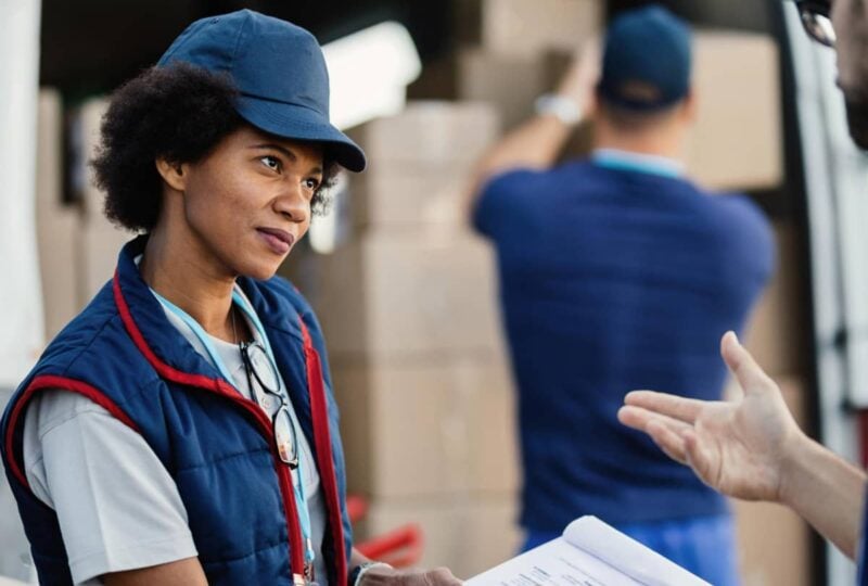 Coordinator checking shipping documents at a loading bay