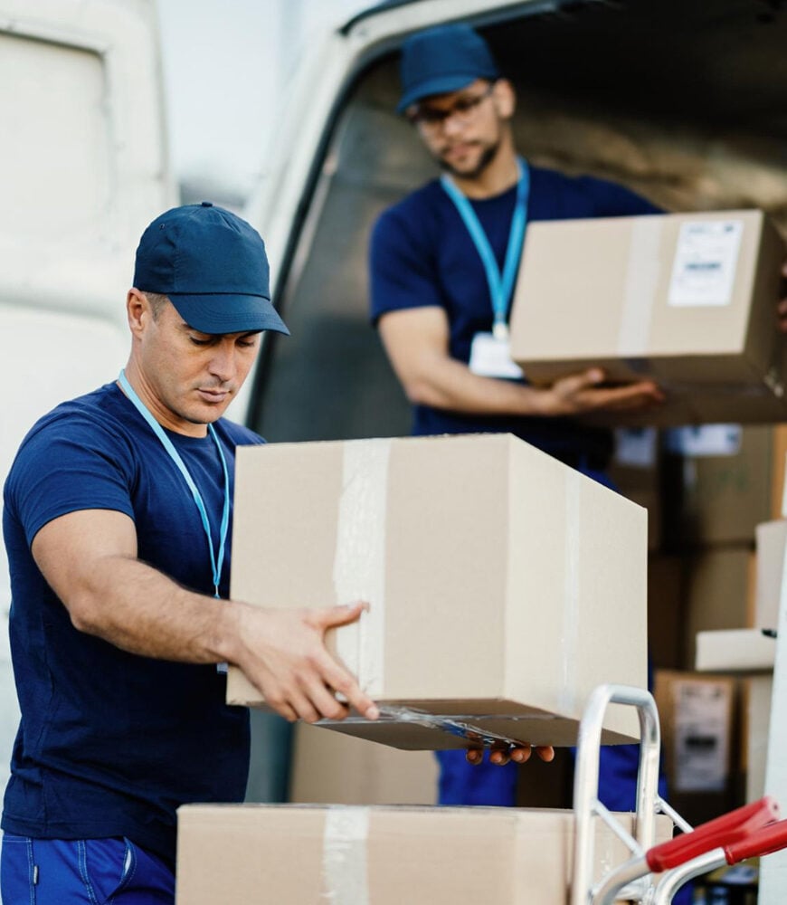 Delivery team loading retail cartons into a distribution van
