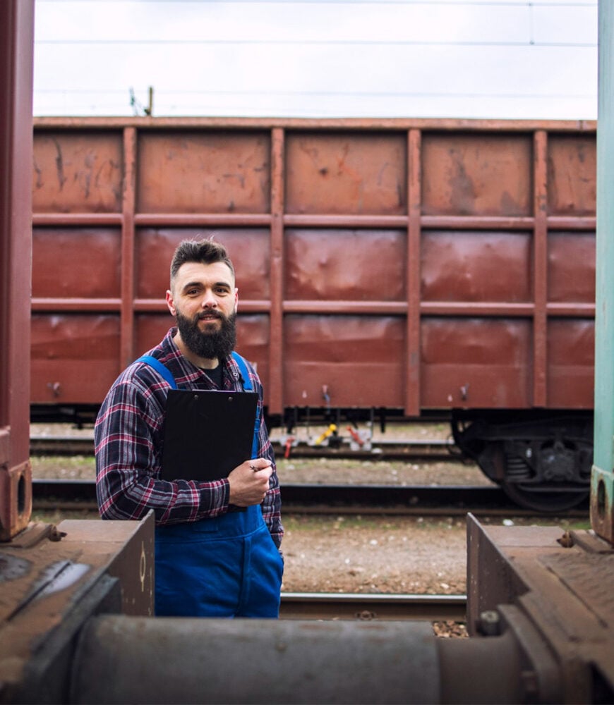 Inspector checking heavy cargo loaded on rail wagons
